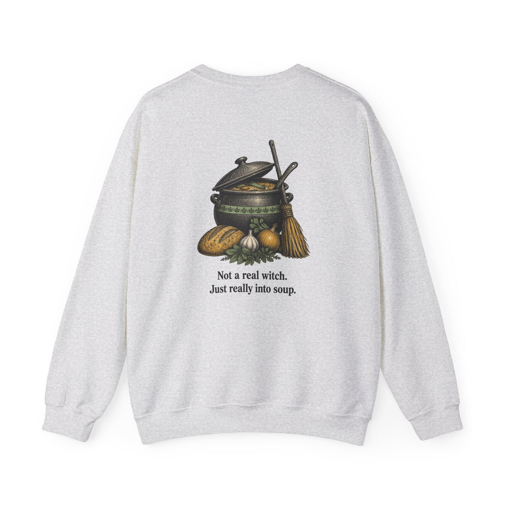 Back of the Ash Kitchen Witch sweatshirt showing a soup pot and broom and “Not a real witch. Just really into soup.”